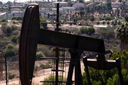 In this May 18, 2021, file photo, homes sit on a hill behind pump jacks operating at the Inglewood Oil Field in Los Angeles. California's oil regulator wants to ban new oil and gas drilling within 3,200 feet of schools, homes and hospitals to protect public health. The draft rule released Thursday, Oct. 21, 2021, would be the nation's largest buffer zone between drilling and community sites if adopted.