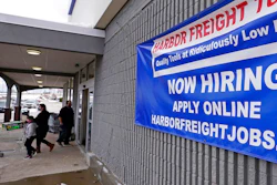 In this Dec. 10, 2020, file photo, a 'Now Hiring' sign hangs on the front wall of a Harbor Freight Tools store in Manchester, N.H. When the U.S. government issues the September jobs report on Friday, Oct. 8, 2021, the spotlight will fall not only on how many people were hired last month. A second question will command attention, too: Are more people finally starting to look for work?