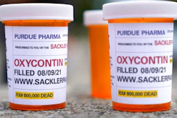 In this Aug. 9, 2021, file photo, fake pill bottles with messages about OxyContin maker Purdue Pharma are displayed during a protest outside the courthouse where the bankruptcy of the company is taking place in White Plains, N.Y. A federal judge on Wednesday, Oct. 13 allowed Purdue Pharma to resume its work carrying out the recent $10 billion settlement plan that allowed the Oxycontin maker to emerge from bankruptcy.