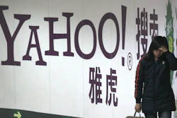 A woman walks past a Yahoo billboard in a Beijing subway in this March 17, 2006. Yahoo Inc. on Tuesday, Nov. 2, 2021 said it plans to pull out of China, citing an 'increasingly challenging business and legal environment.'