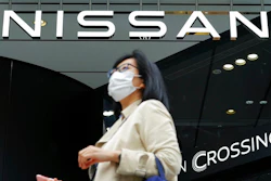A woman walks the Nissan automaker's showroom in Tokyo Tuesday, May 11, 2021. Nissan reported Tuesday, Nov. 9, 2021, a 54.1 billion yen ($479 million) profit for the July-September quarter, a reversal from the 44 billion yen loss racked up last year, despite the continuing damage from the computer chip sshortage slamming the auto industry.
