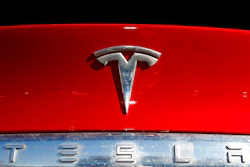 The Tesla company logo sits on an unsold 2020 Model X at a Tesla dealership in Littleton, Colo., on Feb. 2, 2020. Tesla has issued a recall that will automatically send a software update fixing a safety problem in its electric vehicles. The recall on Tuesday, Nov. 2, 2021, apparently heads off a looming confrontation with U.S. safety regulators.