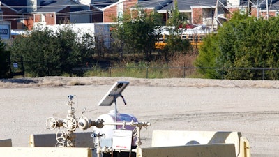 A natural gas well is juxtaposed with apartment buildings a few hundred feet away in Arlington, Texas, on Monday, Oct. 25, 2021. The site, known as 'AC-360,' is operated by TEP Barnett, a subsidiary of French energy giant Total Energies. It is one of Total's 33 well sites in Arlington that contain 163 wells. The company has proposed adding three new wells at this site. Some residents of the predominately Hispanic and Black neighborhood, as well as parents and staff at a daycare near the site, oppose the plan, citing health concerns.