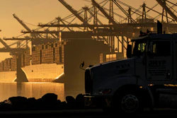 A truck arrives to pick up a shipping container near vessels moored at Maersk APM Terminals Pacific at the Port of Los Angeles on Nov. 30, 2021.