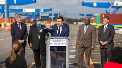 Transportation Secretary Pete Buttigieg speaks to the media during a visit to the Georgia Ports Authority's Megarail facility, on Dec., 17, 2021 in Savannah, Ga. Clogged U.S. ports are being given access to nearly $450 million in federal money from President Joe Biden's new infrastructure law, part of the administration's recent stepped-up efforts to ease supply chain congestion and lower prices for American consumers.