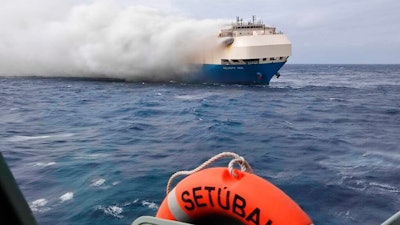 In this undated photo provided by the Portuguese Navy, smoke billows from the burning Felicity Ace car transport ship as seen from the Portuguese Navy NPR Setubal ship southeast of the mid-Atlantic Portuguese Azores Islands. The ship's crew were taken by helicopter to Faial island on the archipelago, about 170 kilometers (100 miles) away on Wednesday, Feb. 16, 2022. There were no reported injuries.