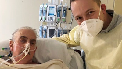 David Bennett Jr., right, stands next to his father's hospital bed in Baltimore, Md., Jan. 12, 2022.