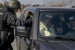 A Ukrainian police officer offer tulips to female travelers at a checkpoint on the outskirts of Kyiv, March 20, 2022.