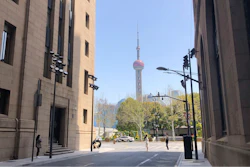 Residents walk along a quiet street with a view of the Oriental Pearl TV Tower in Shanghai, China, Tuesday, March 29, 2022. A two-phase lockdown of Shanghai's 26 million people is testing the limits of China's hard-line 'zero-COVID' strategy, which is shaking markets far beyond the country's borders.