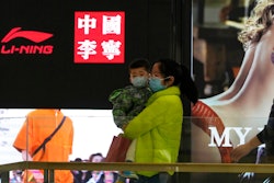 Visitors to a mall walk past signs of Chinese sports brand Li Ning on Wednesday, March 16, 2022, in Beijing. The U.S. customs agency says it is holding imported goods from Li Ning after an investigation indicated they were made by North Korean labor. U.S. law prohibits imports of goods made in North Korea or by North Korean citizens without proof they weren’t made by forced labor, according to a notice from the U.S. Customs and Border Protection in Washington.