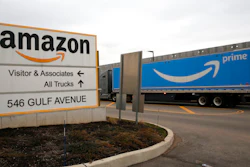 An Amazon Prime truck passes by a sign outside an Amazon fulfillment center March 19, 2020 in Staten Island, N.Y. The National Labor Relations Board has found merit to a complaint that Amazon violated labor law in New York City’s Staten Island by holding mandatory worker meetings to persuade its employees not to unionize. The agency’s determination was shared Friday, May 6, 2022 with an attorney representing the Amazon Labor Union, which filed the charge in the lead-up to the first successful U.S. organizing effort in the retail giant’s history.