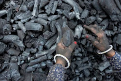 A woman works at a coal depot in Ahmedabad, India, Monday, May 2, 2022. An unusually early and brutal heat wave is scorching parts of India, where acute power shortages are affecting millions as demand for electricity surges to record levels. Supplies of coal at many thermal power plants are running perilously low, spawning daily power outages in several states. The shortages are sparking scrutiny of India’s long reliance on coal, which produces 70% of the country’s electricity.