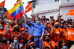 Venezuela opposition leader Juan Guaido poses for a group photo with residents after presenting his unity plan for Venezuelans, in Maiquetia, Venezuela, Saturday, Feb. 19, 2022. The faction of the Venezuelan opposition backed by the United States says it plans to hold primary contests next year to choose a presidential candidate for the planned 2024 election.