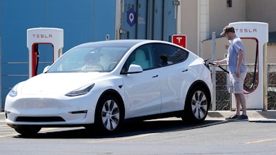 A Tesla owner charges his vehicle at a charging station in Topeka, Kan., Monday, April 5, 2021.