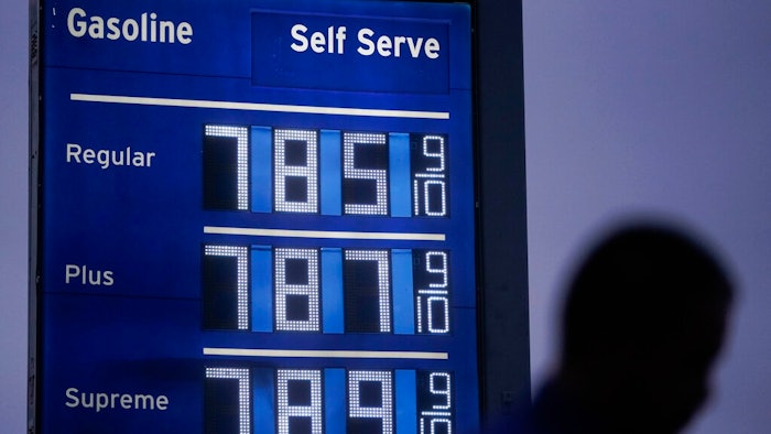 High gas prices are shown as a pedestrian waits to cross the street in Los Angeles, June 16, 2022. President Joe Biden on June 22 will call on Congress to suspend the federal gasoline and diesel taxes for three months. It's a move meant to ease financial pressures at the pump that also reveals the political toxicity of high gas prices in an election year.
