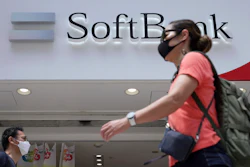 People walk by a SoftBank shop on Monday, Aug. 8, 2022, in Tokyo. Japanese technology company SoftBank Group sank into losses for the first fiscal quarter as the value of its investments declined amid global worries about inflation and interest rates.