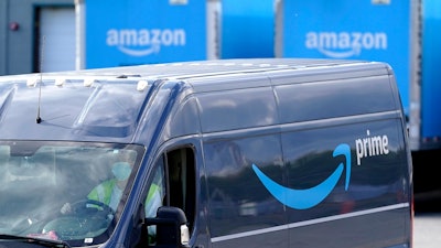 A delivery van departs an Amazon warehouse in Dedham, Mass., Oct. 1, 2020.