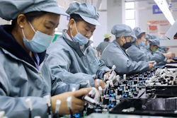 Workers wearing face masks assemble electronic parts at a factory in Huaibei in central China's Anhui Province on Nov. 29, 2021. Chinese manufacturing contracted in August 2022 amid weak export and consumer demand, a survey showed Wednesday, Aug. 31, 2022, adding to downward pressure on the struggling economy.