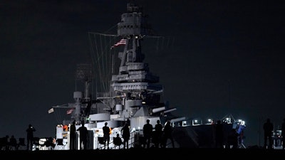 People watch as the USS Texas is moved from the dock Wednesday, Aug. 31, 2022, in La Porte, Texas. The vessel, which was commissioned in 1914 and served in both World War I and World War II, is being towed down the Houston Ship Channel to a dry dock in Galveston where it will undergo an extensive $35 million repair.