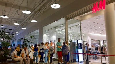 People line up to enter an H&M shop and buy items on sale in the Aviapark shopping mall in Moscow, Russia, Tuesday, Aug. 9, 2022. Russians are snapping up Western fashion and furniture this week as H&M and IKEA sell off the last of their inventory in Russia, moving forward with their exit from the country after it sent troops into Ukraine. Sweden-based H&M and Netherlands-based IKEA had paused sales in Russia after the military operation began and are now looking to unload their stocks of clothing and furnishings as they wind down operations there.