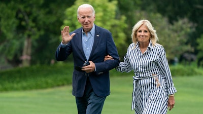 President Joe Biden with first lady Jill Biden waves as they walk on the South Lawn of the White House in Washington, upon arrival from a trip to visit flood affected areas in Kentucky, Monday, Aug. 8, 2022.