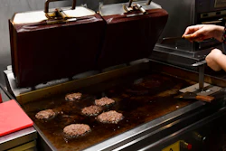 A worker cooks burgers at Zing Burger store in Budapest, Hungary, Monday, Sept. 12, 2022. Richard Kovacs, a business development manager for the Hungarian burger chain, said some of the chain's 15 stores have seen a 750% increase in electricity bills since the beginning of the year – leading to additional monthly costs of up to 1.5 million Hungarian forints ($3,840) per store.