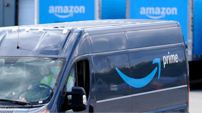 An Amazon Prime logo appears on the side of a delivery van as it departs an Amazon Warehouse location in Dedham, Mass., Oct. 1, 2020.