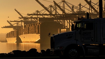 A truck arrives to pick up a shipping container near vessels at the Port of Los Angeles, on Nov. 30, 2021. An influential government advisory panel comprised of major U.S. businesses is proposing new rules that would roll back already limited public access to import data, a move that trade experts say would make it harder to trace labor abuse by foreign suppliers. The proposal, if adopted, would shroud in secrecy customs data on ocean-going freight responsible for about half of the $2.7 trillion worth of goods entering the U.S. every year in the same way it already is for rail, truck and air cargo.