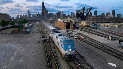 An Amtrak passenger train departs Chicago in the early evening headed south on Sept. 14, 2022, in Chicago. American consumers and nearly every industry will be affected if freight trains grind to a halt in December. Roughly half of all commuter rail systems rely at least in part on tracks that are owned by freight railroads, and nearly all of Amtrak’s long-distance trains run over the freight network.