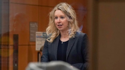 Theranos founder and CEO Elizabeth Holmes, center, walks into federal court with her partner Billy Evans, right, and her parents in San Jose, Calif., Friday, Nov. 18, 2022. A federal judge will decide whether Holmes should serve a lengthy prison sentence for duping investors and endangering patients while peddling a bogus blood-testing technology.