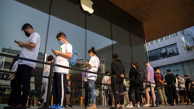 Customers line up outside of an Apple Store before its opening on the first day of sale for the Apple iPhone 14 in Beijing, China on Sept. 16, 2022. Apple Inc. is warning customers will have to wait longer to get its latest iPhone models after anti-virus restrictions were imposed on a contractor's factory in central China.