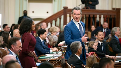 California Gov. Gavin Newsom walks through the assembly chamber with California Controller Malia Cohen during the opening session of the California Legislature in Sacramento, Calif., Monday, Dec. 5, 2022. The legislature returned to work on Monday to swear in new members and elect leaders for the upcoming session.