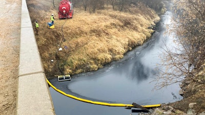 A remediation company deploys a boom on the surface of an oil spill after a Keystone pipeline ruptured at Mill Creek in Washington County, Kansas, on Thursday, Dec. 8, 2022. Vacuum trucks, booms and an emergency dam were constructed on the creek to intercept the spill.