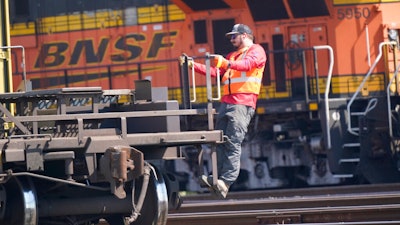 A worker rides a rail car at a BNSF rail crossing in Saginaw, Texas, Wednesday, Sept. 14, 2022. Most railroad workers weren't surprised that Congress intervened this week to block a railroad strike, but they were disappointed because they say the deals lawmakers imposed didn't do enough to address their quality of life concerns about demanding schedules and the lack of paid sick time.