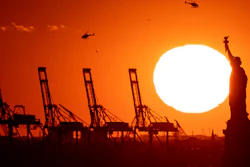 Container cranes at a port in New Jersey behind the Statue of Liberty, Nov. 20, 2022.
