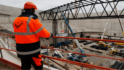 A worker looks at the Paris2024 Olympics Porte de la Chapelle Arena building site Monday, Jan. 23, 2023 in Paris.