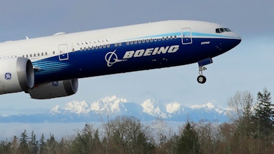 In this Jan. 25, 2020, file photo a Boeing 777X airplane takes off on its first flight with the Olympic Mountains in the background at Paine Field in Everett, Wash.