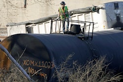 A cleanup worker stands on a derailed tank car of a Norfolk Southern freight train in East Palestine, Ohio, continues, Feb. 15, 2023.