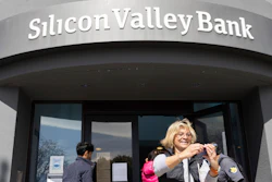 A woman who was part of a line entering the Silicon Valley Bank's headquarters pauses for a selfie in Santa Clara, Calif., on Monday, March 13, 2023.