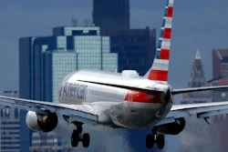 An American Airlines plane lands at Logan International Airport, Thursday, Jan. 26, 2023, in Boston. Communities around the world emitted more carbon dioxide than any other year on record in 2022 as air travel rebounded from the pandemic and cities turned to coal to provide a cheap source of power.