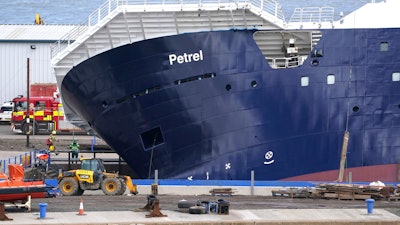 Emergency services work at Imperial Dock, where a ship has become dislodged from its holding and is partially toppled over, in Leith, Edinburgh, Scotland, Wednesday March 22, 2023.