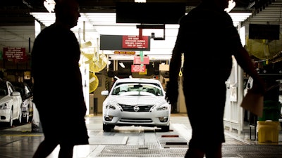 Workers at the Nissan plant in Smyrna, Tenn., walk by a Nissan Altima sedan, May 15, 2012.