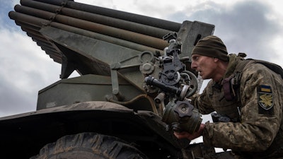 A Ukrainian paratrooper of 95 Air Assault brigade aims to fire by MSLR BM-21 'Grad' towards Russian positions at the frontline near Kreminna, Ukraine, Thursday, March 9, 2023.