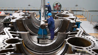 In this photo released by Xinhua News Agency, workers assemble an equipment at Harbin Turbine Company Limited of Harbin Electric Corporation in Harbin in northeastern China's Heilongjiang Province on Friday, April 28, 2023.