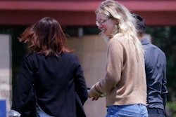 Disgraced Theranos CEO Elizabeth Holmes, center, is escorted by prison officials into a federal women's prison camp on May 30, 2023, in Bryan, Texas.