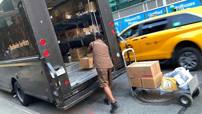 A United Parcel Service driver loads his truck adjacent to a UPS Store in New York, May 11, 2023.