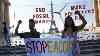 Climate activists Patience Nabukalu, of Uganda, left, and Mitzi Jonelle Tan, of the Philippines, participate in a demonstration ahead of the Global Climate Finance Summit, Wednesday, June 21, 2023 in Paris. The aim of a two-day climate and finance summit in Paris that ends Friday, June 23, was to set up concrete measures to help poor and developing countries better tackle issues like poverty and climate change.