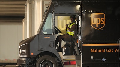 A UPS driver puts his seat belt on before driving off during a rally in downtown Los Angeles, July 19, 2023.