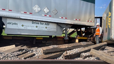 A worker stands among derailed freight cars near Havre, Montana, July 21, 2023.