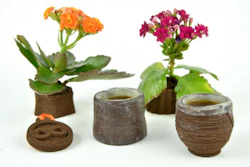 A pendant, espresso cups and flower planters 3D printed from used coffee grounds.
